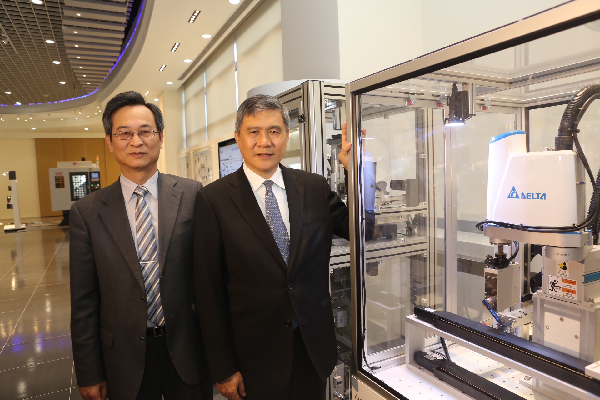 图3_台达海英俊董事长 (右)与机电事业群张训海总 经理展示台达多工机器人弹性工作站